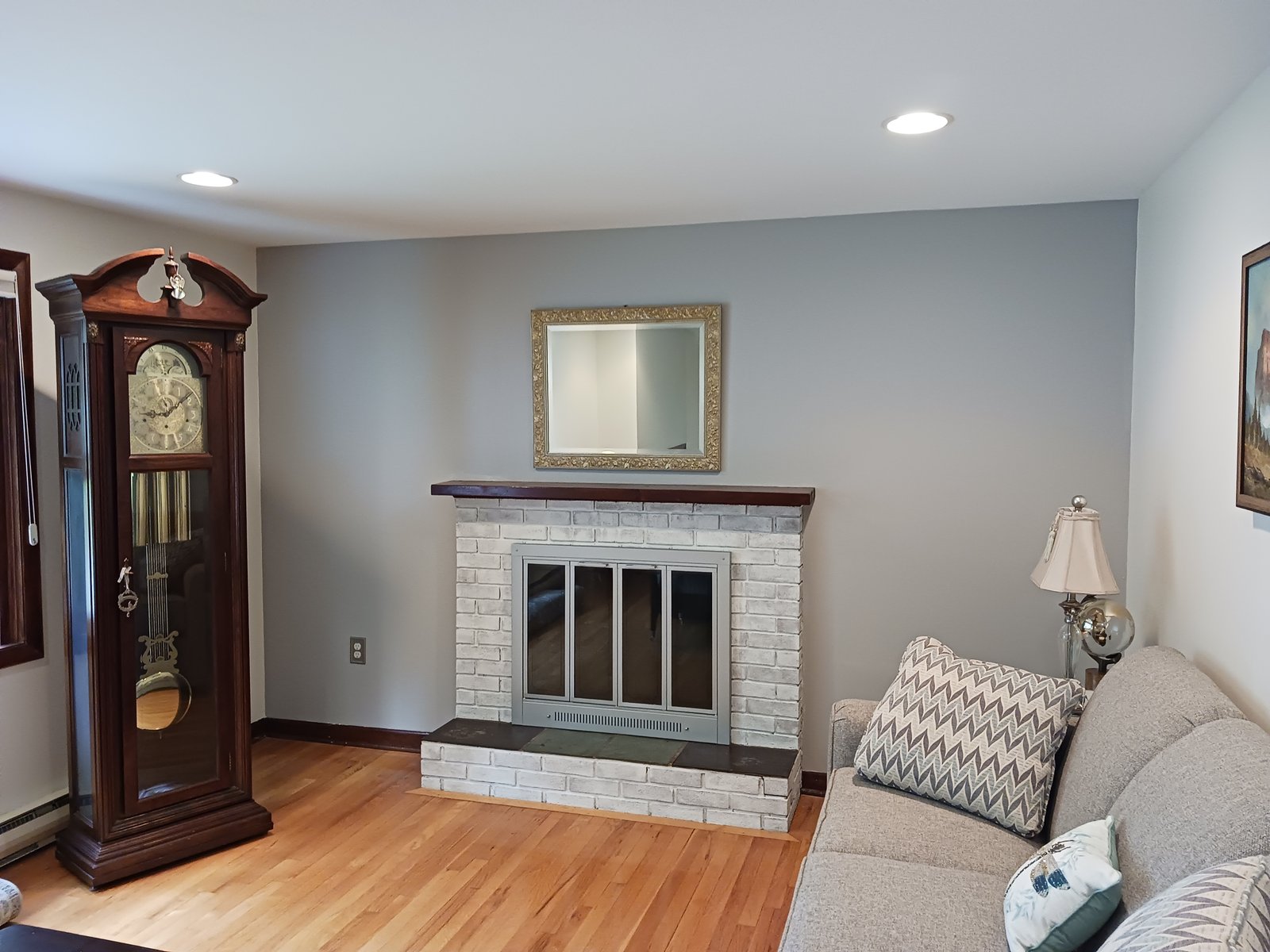 Interior living room — gray walls, white fireplace, hardwood floor